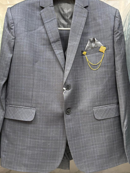 A gray plaid two-button suit jacket with a matching pocket square and gold chain accessory, displayed on a hanger.