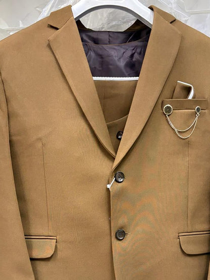 A tan men's blazer jacket with a matching vest underneath, hanging on a white hanger against a crinkled light gray background.